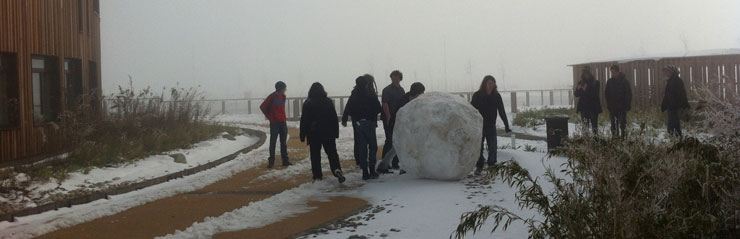 The base of a very large snowman being rolled into place outside University of York's Computer Science building